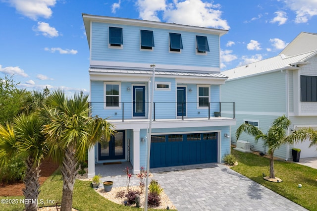 548 Sea Island Dr, Fernandina Beach, FL 32034 - view of front of home with a balcony, driveway, a garage, metal roof, and a standing seam roof