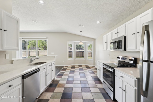86123 Red Holly Pl, Yulee, FL 32097 - kitchen with stainless steel appliances, vaulted ceiling, a sink, and white cabinetry