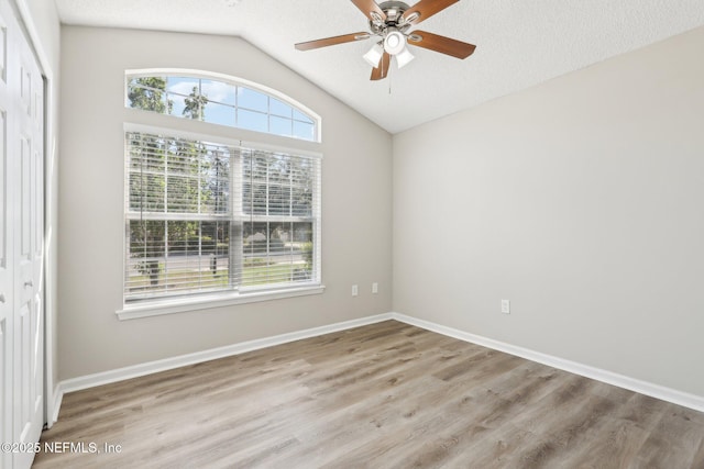 86123 Red Holly Pl, Yulee, FL 32097 - empty room featuring lofted ceiling, a ceiling fan, wood finished floors, and baseboards