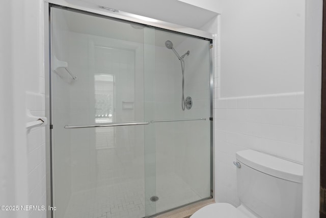 1228 Old Mill Rd, Orlando, FL 32806 - full bathroom with a wainscoted wall, tile walls, toilet, and a shower stall