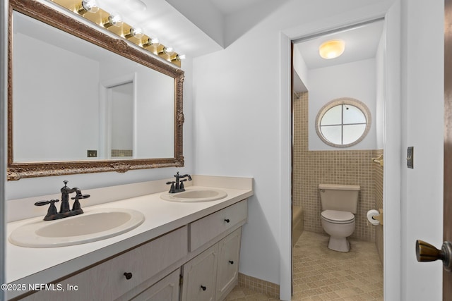 1228 Old Mill Rd, Orlando, FL 32806 - bathroom featuring double vanity, a sink, toilet, and tile walls