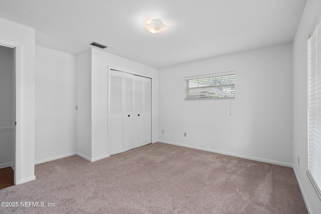 1228 Old Mill Rd, Orlando, FL 32806 - unfurnished bedroom with carpet flooring, baseboards, visible vents, and a closet