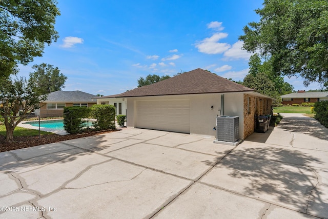 1228 Old Mill Rd, Orlando, FL 32806 - view of property exterior with fence, central AC, a garage, stucco siding, and concrete driveway