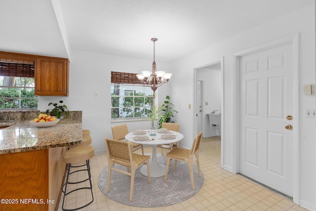1228 Old Mill Rd, Orlando, FL 32806 - dining space featuring light floors, baseboards, and a notable chandelier