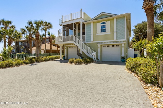 111 Cherry St, Neptune Beach, FL 32266 - coastal home with fence, an attached garage, a balcony, stairway, and decorative driveway