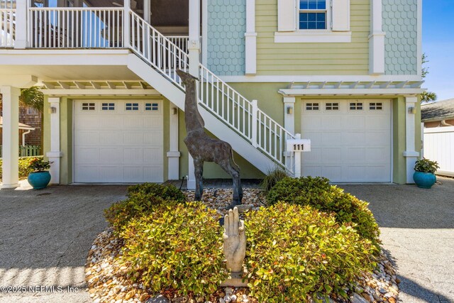 111 Cherry St, Neptune Beach, FL 32266 - view of home's exterior with an attached garage, aphalt driveway, and stairway