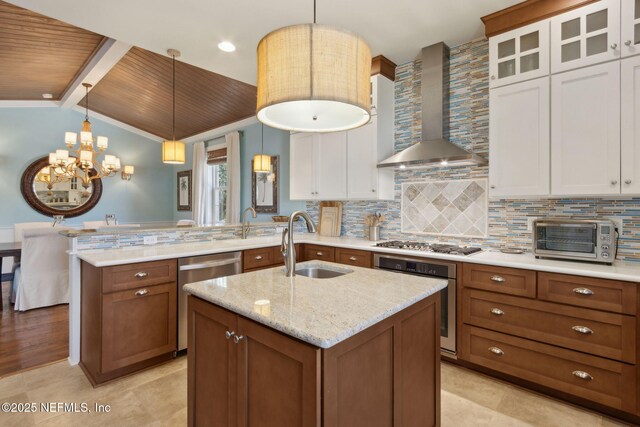 111 Cherry St, Neptune Beach, FL 32266 - kitchen with wall chimney exhaust hood, stainless steel appliances, a peninsula, a sink, and backsplash