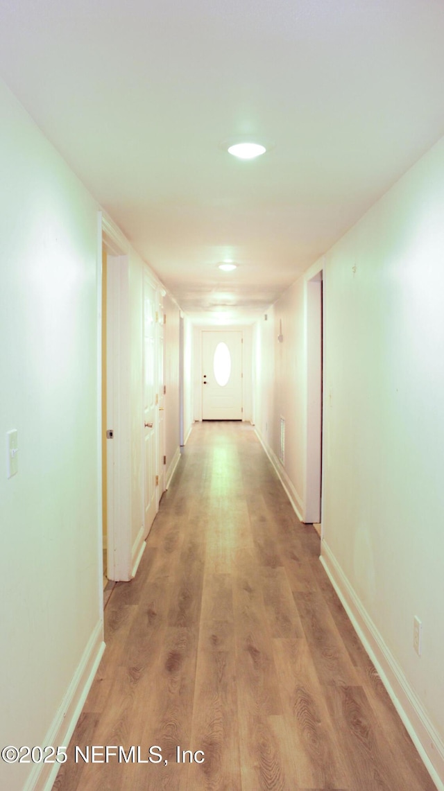 hall featuring baseboards and light wood-style floors
