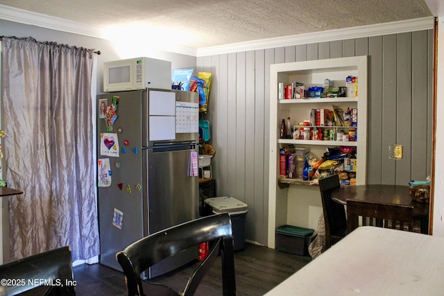 interior space featuring dark wood finished floors, freestanding refrigerator, crown molding, and white microwave