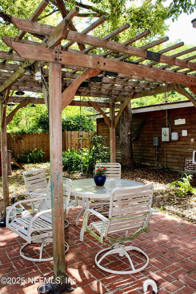 view of patio / terrace featuring a pergola, outdoor dining space, and fence