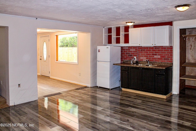 kitchen featuring open shelves, wood finished floors, a sink, white cabinets, and freestanding refrigerator