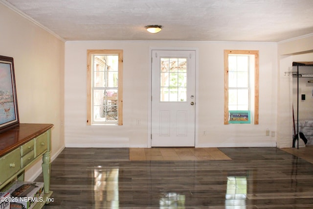 doorway to outside featuring baseboards, crown molding, and wood finished floors