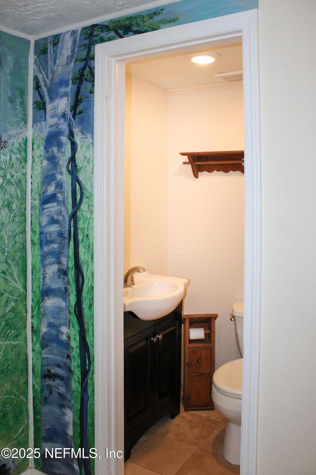 bathroom featuring vanity, tile patterned flooring, and toilet