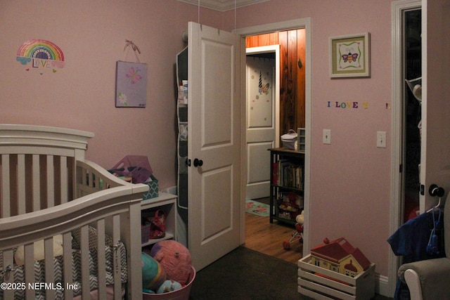 bedroom featuring ornamental molding and wood finished floors