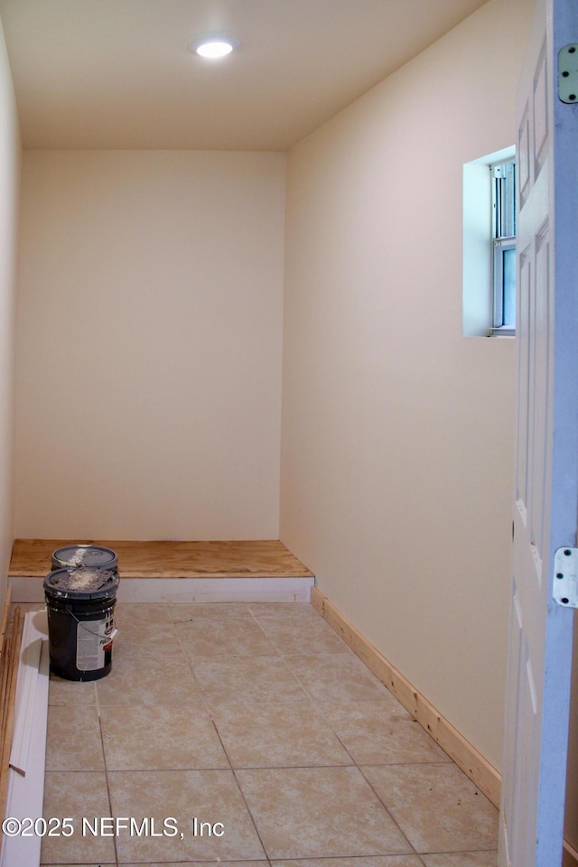 corridor with baseboards, recessed lighting, and light tile patterned floors
