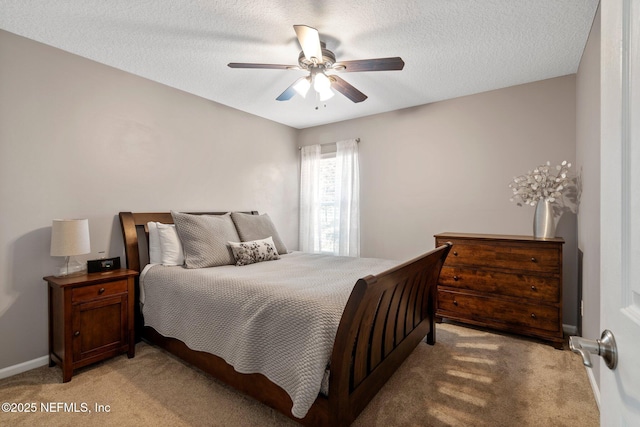 bedroom with ceiling fan, light carpet, and a textured ceiling