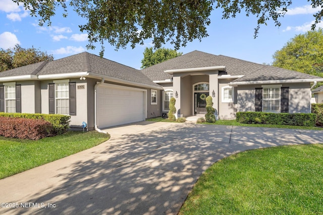 ranch-style home with a shingled roof, a front lawn, stucco siding, an attached garage, and driveway