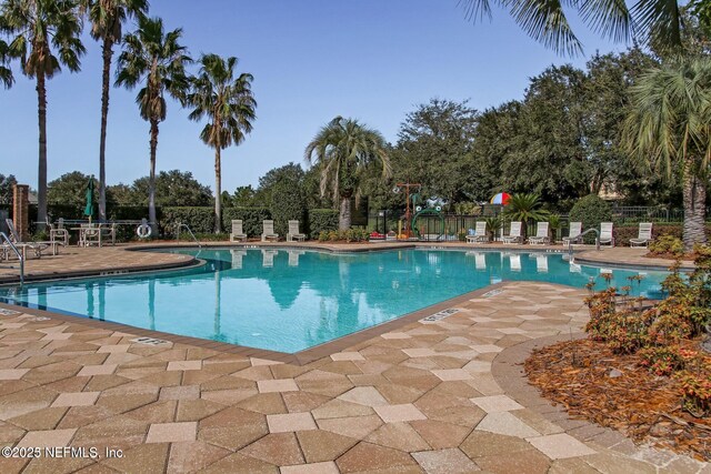 pool with fence and a patio area
