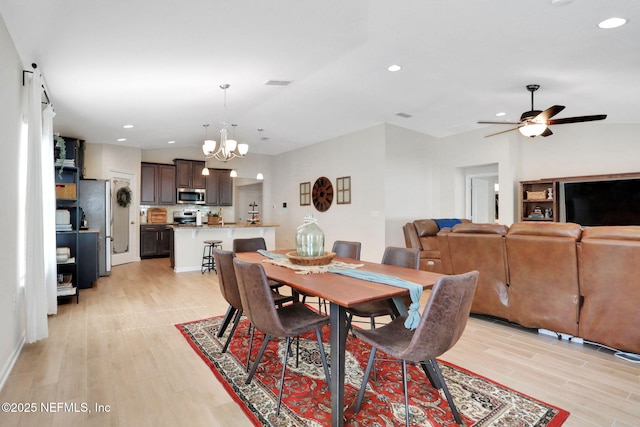 dining area featuring recessed lighting, vaulted ceiling, light wood finished floors, and ceiling fan with notable chandelier