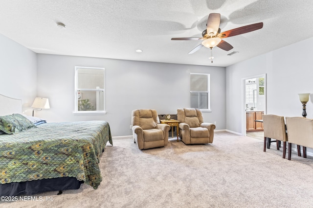 bedroom with light carpet, a textured ceiling, baseboards, visible vents, and a ceiling fan