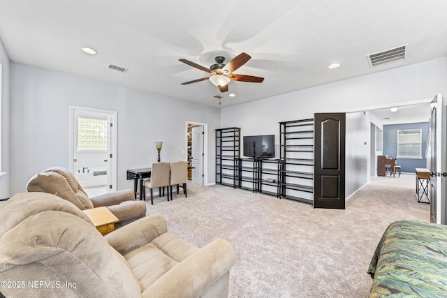 carpeted living area with recessed lighting, visible vents, and a ceiling fan