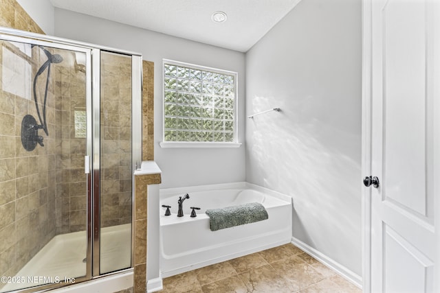 bathroom featuring a garden tub, baseboards, and a shower stall