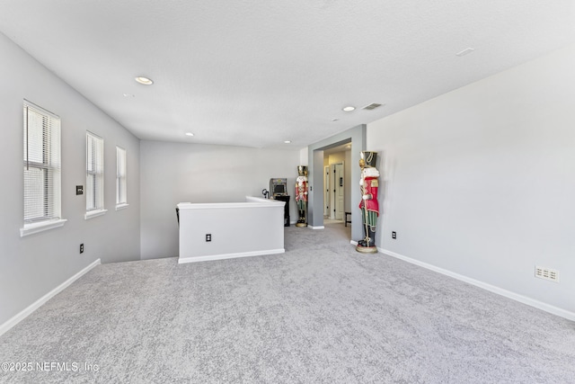 unfurnished living room featuring recessed lighting, carpet, and baseboards