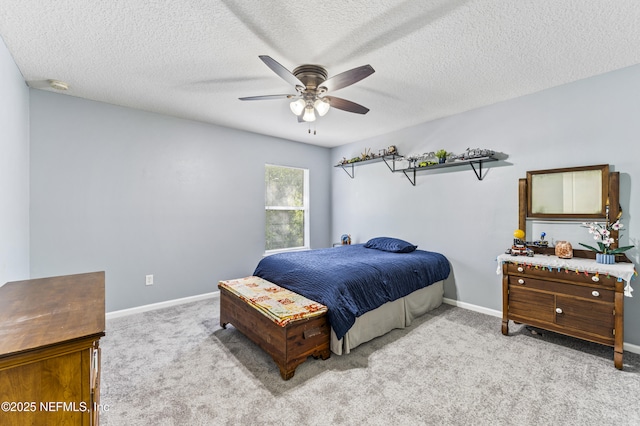 carpeted bedroom featuring ceiling fan, baseboards, and a textured ceiling