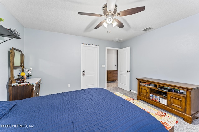 bedroom featuring visible vents, carpet floors, baseboards, a textured ceiling, and ceiling fan