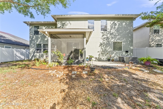 back of house featuring central air condition unit, a sunroom, fence, and a patio