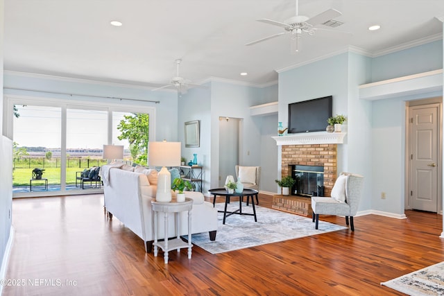 living area featuring a fireplace, a ceiling fan, recessed lighting, and wood finished floors