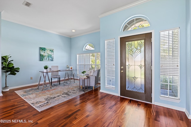 foyer entrance with baseboards, visible vents, ornamental molding, and a healthy amount of sunlight