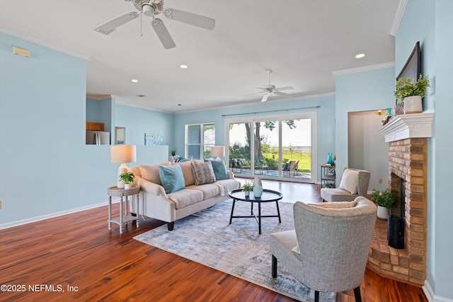 living room featuring crown molding, ceiling fan, a fireplace, recessed lighting, and wood finished floors