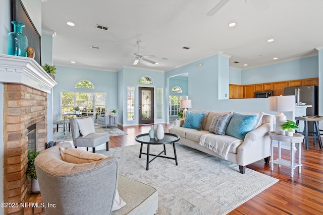 living area featuring ceiling fan, ornamental molding, recessed lighting, and wood finished floors
