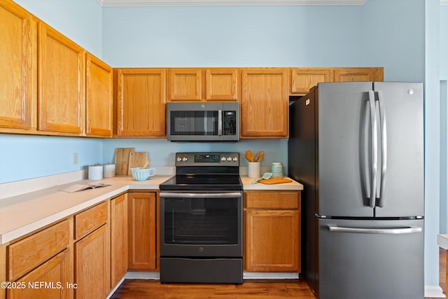 kitchen with light countertops, wood finished floors, and stainless steel appliances