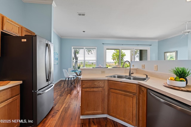 kitchen featuring a sink, appliances with stainless steel finishes, ornamental molding, and visible vents