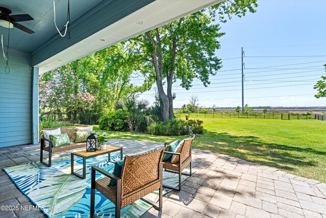 view of patio featuring an outdoor living space, a ceiling fan, and fence