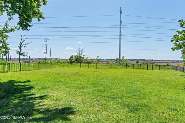 view of yard with fence and a rural view