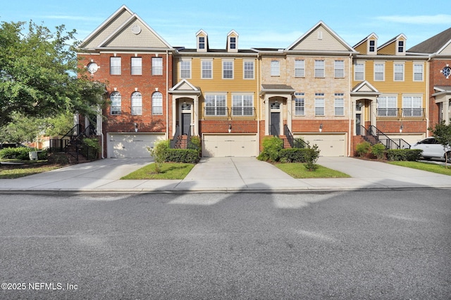 townhome / multi-family property featuring brick siding, an attached garage, and driveway