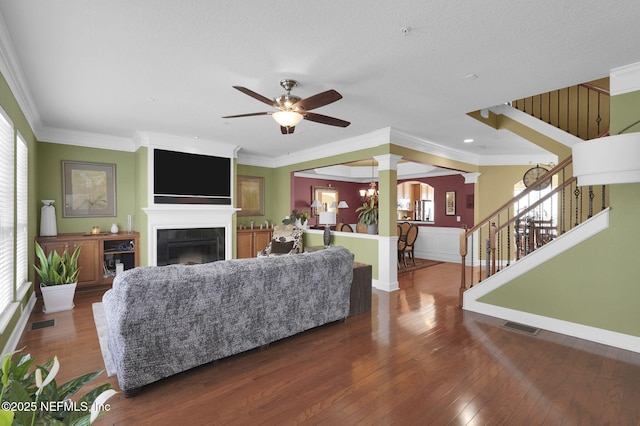 living room with decorative columns, visible vents, ceiling fan, stairway, and a fireplace