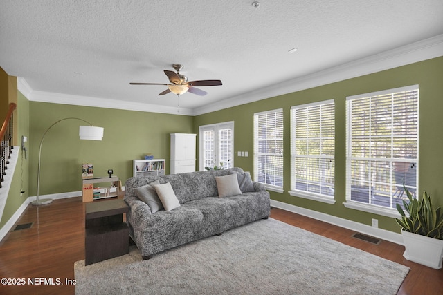 living room with plenty of natural light, visible vents, stairs, and ceiling fan