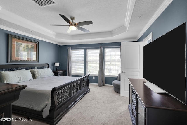 bedroom featuring a textured ceiling, light carpet, a raised ceiling, ornamental molding, and visible vents