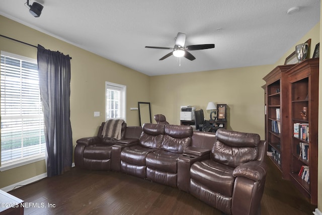 cinema featuring baseboards, dark wood-type flooring, and ceiling fan