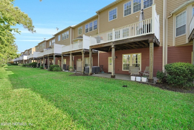rear view of property with a lawn, a residential view, central air condition unit, and a patio