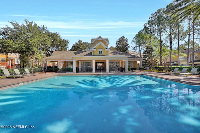 community pool with a patio and fence