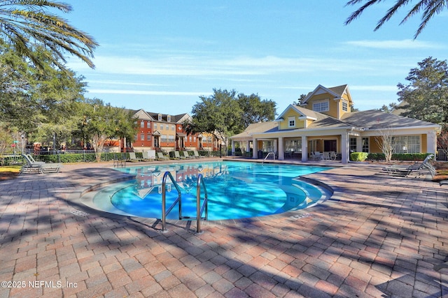 community pool featuring fence and a patio area
