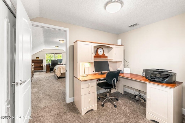 office area featuring light colored carpet, a textured ceiling, lofted ceiling, and visible vents