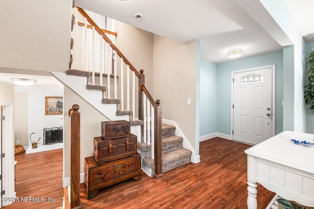 entryway with baseboards, dark wood-style floors, and stairway