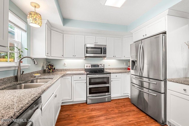 kitchen with a sink, appliances with stainless steel finishes, and white cabinetry