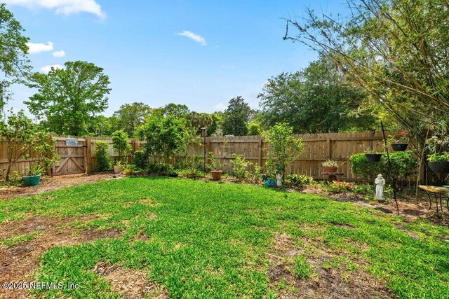 view of yard featuring a gate and a fenced backyard